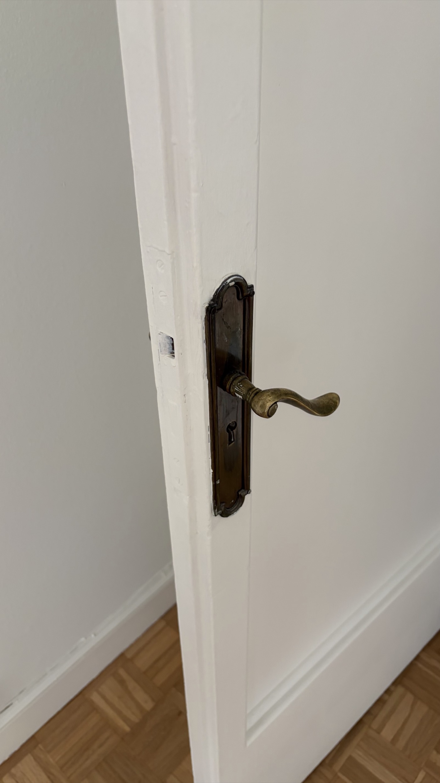 Antique brass door handle on old white door