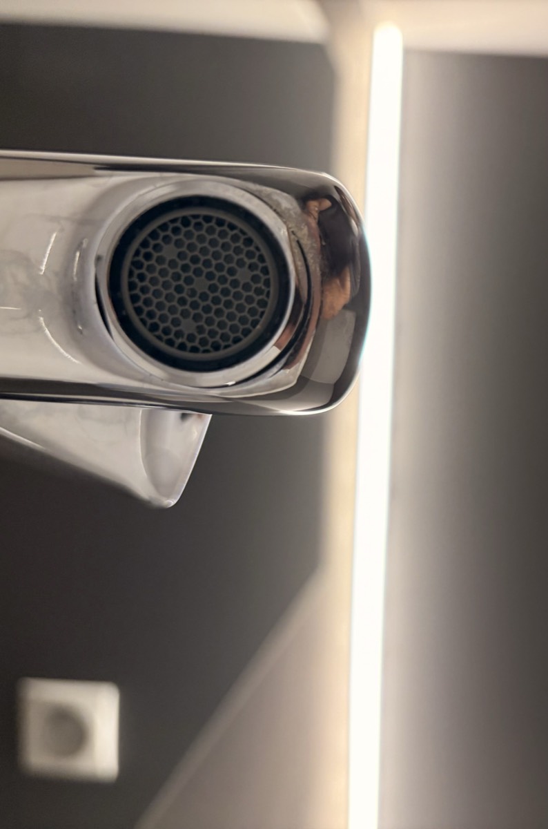 Close-up of a faucet aerator showing the mesh screen