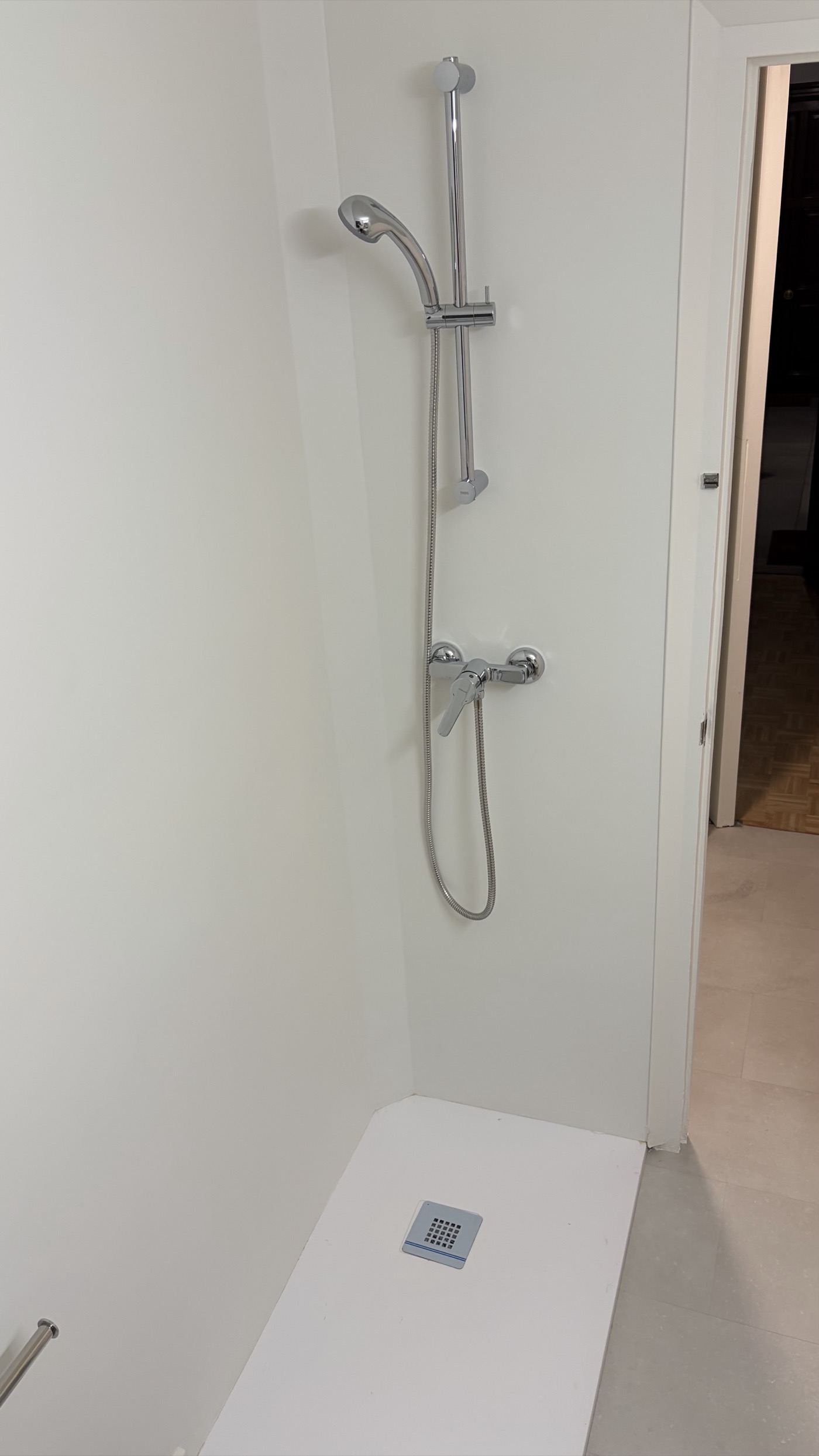 Walk-in shower with tray and rail shower head but no screen or curtain