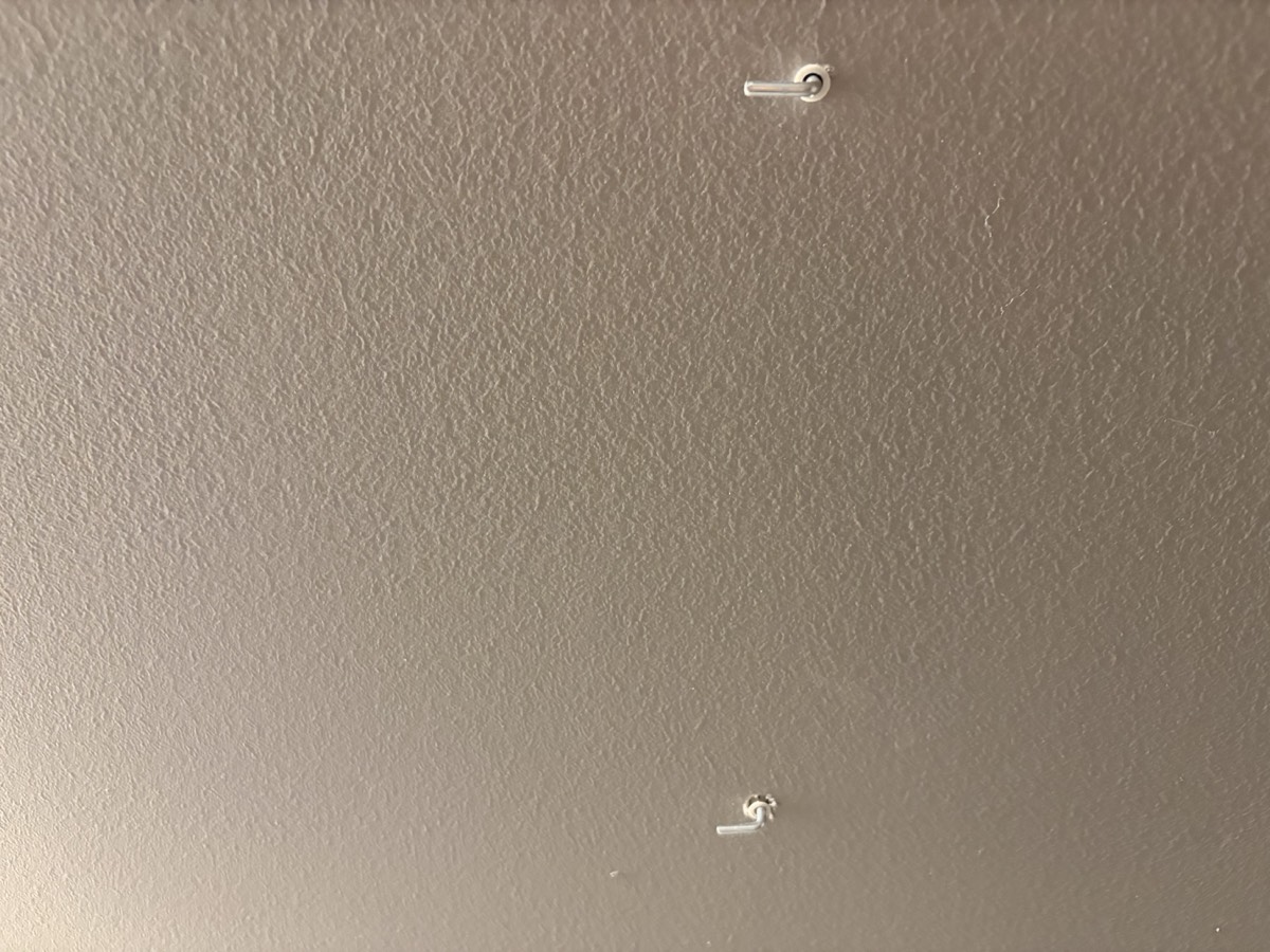 Two wall anchor holes on a painted wall
